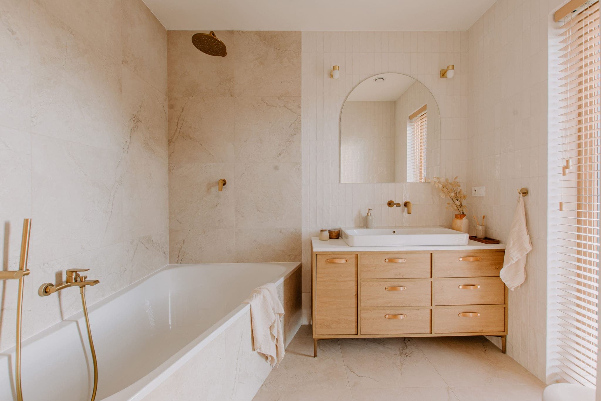 Modern refinished bathroom with white vanity and brushed-gold fixtures