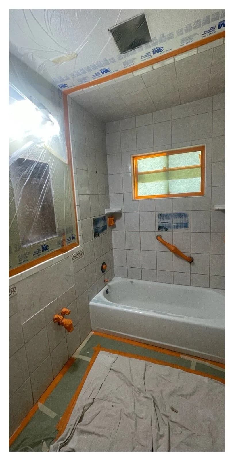 Before: Tub and gray tile surround masked for refinishing beside the same surround refinished in clean white